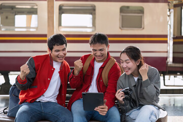 Fototapeta premium Joyful Moments and Travel. Friends gathered around a tablet, cheering for their travel exploits.