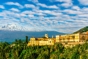 beautiful landscape of Taormina town, Italy, Sicily with scenic view at San Domenico hotel near nice buildings and panoramic view of Etna mountain on background