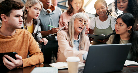 Education, students and lecturer with laptop, pointing and info for assignment in classroom and group. Knowledge, teacher and mature woman with advice for project, people and discussion in university
