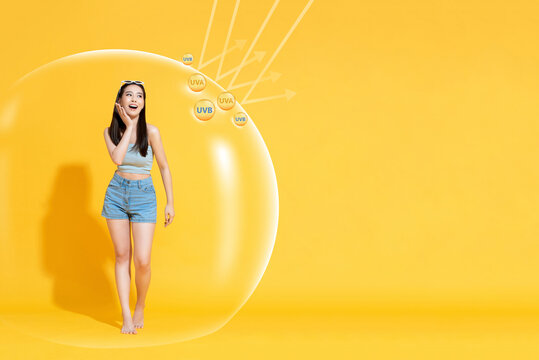 Portrait of beautiful Asian woman wearing casual summer outfit walking in bubble protected from UV ray, skincare sunblock and sunscreen concept, with copy space for text
