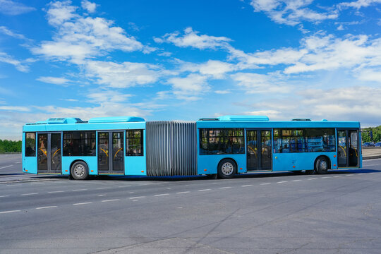 Passenger lengthened articulated bus city bus of blue color turn rides at the highway