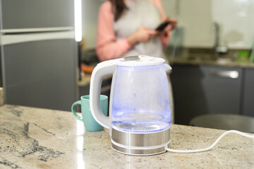 Modern glass electric kettle with boiling water.