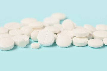 Many white pills on blue background
