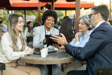 Business people having a meeting at outdoor cafe using digital tablet