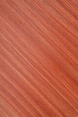Detailed close-up of reddish-brown wood grain texture with consistent diagonal lines, perfect for natural backgrounds or surface design elements.