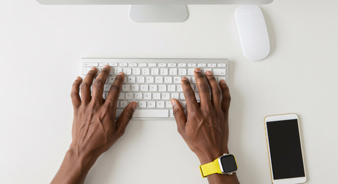 African American Man Typing on Computer Keyboard Desk Top View