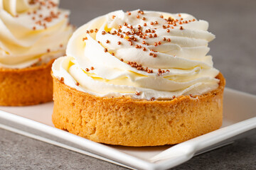 Lemon tartlets with whipped cream, sprinkles and chocolate chips on white background