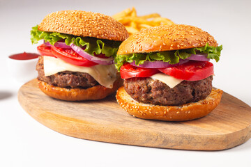 Hamburger made of beef, onion, tomato, lettuce, cheese and spices. Fresh burger closeup. Cheeseburger.