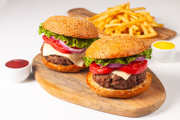 Hamburger made of beef, onion, tomato, lettuce, cheese and spices. Fresh burger closeup. Cheeseburger.