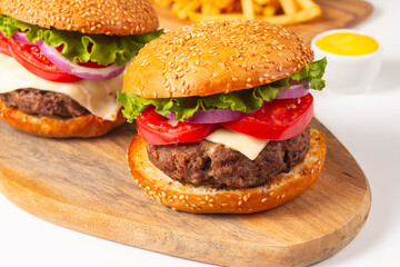 Hamburger made of beef, onion, tomato, lettuce, cheese and spices. Fresh burger closeup. Cheeseburger.