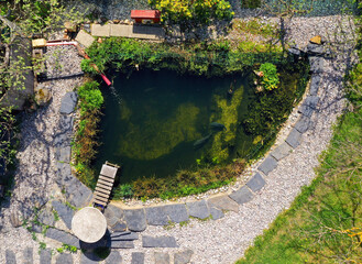 Root wastewater treatment plant as a garden pond. Relaxation zone with fish farming in an organic garden from above. Sustainable development in gardening and aquaculture.