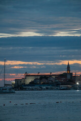 Fototapeta premium Citadel against the sunset on the shore of the Adriatic Sea. The ancient 15th century St. Mary's Fortress in Budva, Montenegro. Vertical image