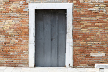 Old Metal Door in Brick Wall with Stone Frame