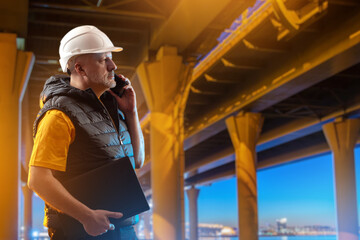 Man road infrastructure architect. Builders talking on phone. Architectural engineer stands under...
