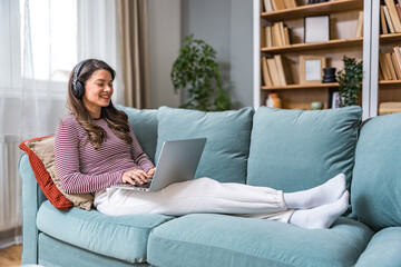 Fototapeta premium Young woman former victim of domestic violence relax in her apartment has a video call on laptop computer explain and talk about how to reclaim life and have strength to let go of toxic relationships.