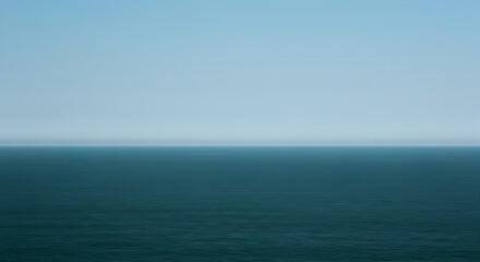 Fototapeta premium Calm Ocean Waters Under a Clear Pale Blue Sky On The Horizon