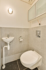 a white toilet and sink in a small bathroom with black tiles on the floor, walls and ceiling above it