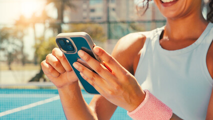 Tennis, hands and woman on court with mobile, social media or scroll on training app for exercise tips. Athlete, smile or phone on sports ground for blog update, fitness research or club registration