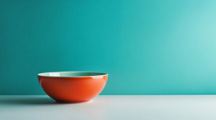 Red ceramic bowl on turquoise minimalist background
