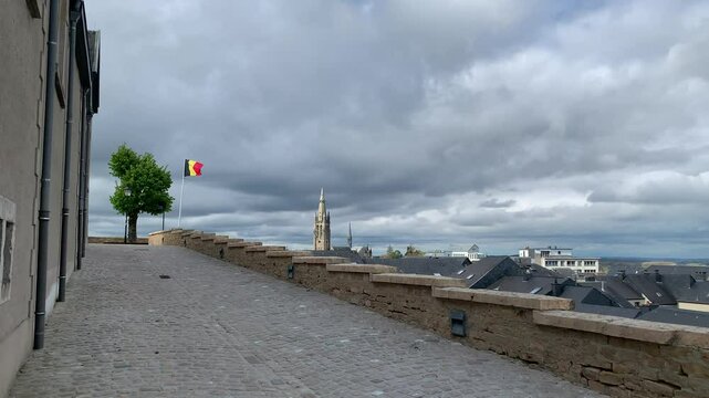 Panoramic, scenic skyline view of Arlon city buildings rooftops and Saint Martin church. Belgian flag is waving on top of Saint Donat church hill.  Arlon, Belgium