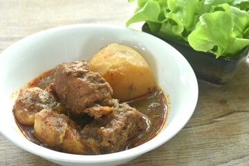 beef curry or Mussamun Indian food with slice potato on bowl eat with fresh green oak