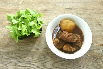 beef curry or Mussamun Indian food with slice potato on bowl eat with fresh green oak