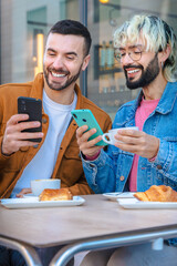 Smiling friends sit together at an outdoor cafe, enjoying coffee and pastries while looking at a smartphone. Relaxed moment of connection, modern lifestyle and social interaction in urban setting.