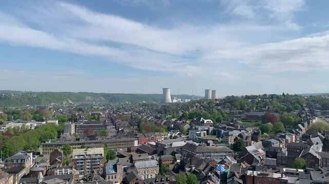Panoramic, scenic aerial view of Huy city, mountains and chimneys of nuclear power plant. Airplane is flying above and descending towards Liege airport. View from Fort de Huy. Huy, Belgium