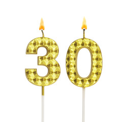 Burning gold birthday candles isolated on white background, number 30.	
