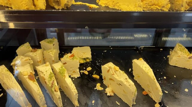 sweetness halva Halva Takhinin. Eastern Bazaar. Counter, oriental sweets with nuts in the assortment
