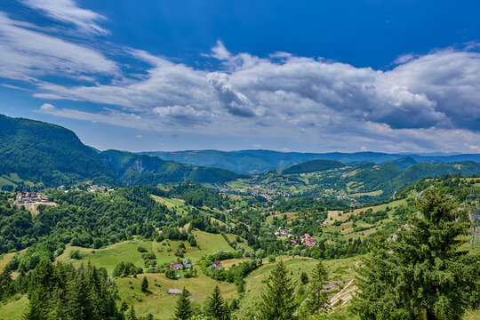 Panorama view of mountain range and valley with the town of Podu Dambovitei overview from the Oratia Viewing Point beside the highway E574, Romania, Europe