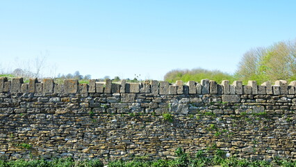 Stone wall in the countryside with a blue sky above © 1000 Words