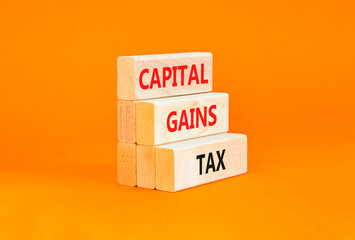Capital gains tax symbol. Concept words Capital gains tax on beautiful wooden block. Beautiful orange table orange background. Business and capital gains tax concept. Copy space.