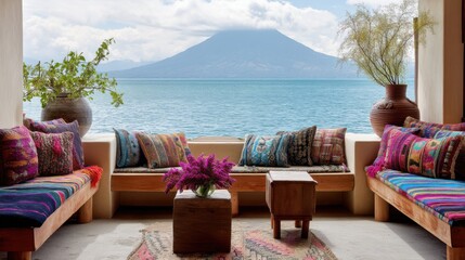 Fototapeta premium Guatemalan lakeside living room with bright textiles, wood benches and view of volcano rising through clouds