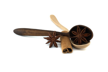 Star anise and cinnamon quill rest on wooden spoons, creating a warm, aromatic still life.