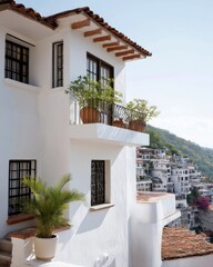Taxco hillside house with white walls, fern shadows and narrow terracotta balcony in sun