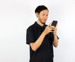 Man Using Mobile Phone, Smiling Indoors in Studio with White Backdrop