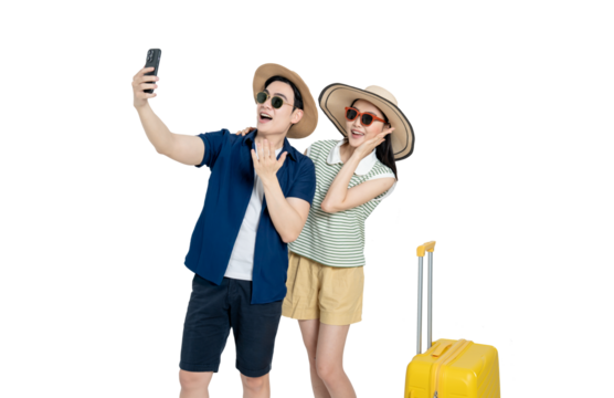 portrait of asian couple wearing travel clothes, suitcases and using phone  posing on white background