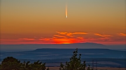 Obraz premium Comet Neowise over landscape at dusk with colorful skies and dramatic mountains