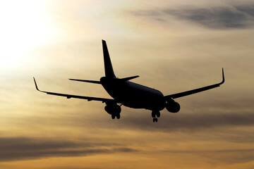 Plane landing, backlit in the sky at a beautiful sunset. A large, beautiful plane. A beautiful image of the sky and the plane landing.