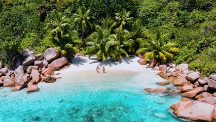 A stunning aerial view captures a couple enjoying a vacation at Anse Lazio on Praslin Island,...