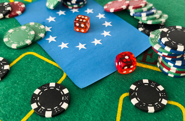 A set of poker chips stack on a green game table with a dice rolls. European Union flag. risk concept - playing poker in casino. Poker game theme. Red casino dice rolls.