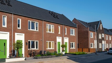 Discover a charming Dutch suburban area featuring modern brick houses designed for families. This inviting neighborhood showcases contemporary architecture, greenery, and a peaceful atmosphere.