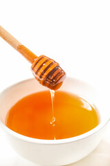 honey dripping in a bowl isolated on white background
