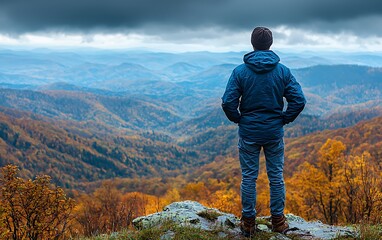 Man standing on mountain peak, autumn view