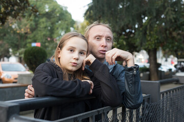 Fototapeta premium Surprised daughter child girl and her father together looking at something. Happy family, leisure activity, weekend and vacation concept