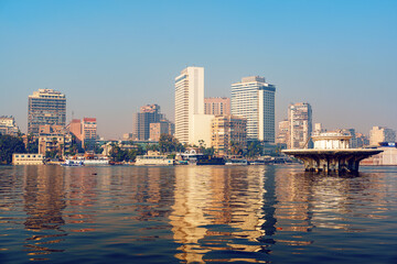 Obraz premium City skyline reflecting in the Nile River at sunset in Cairo