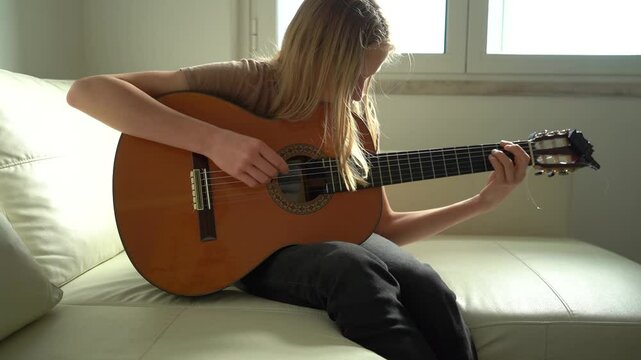 13 year old Teenager Girl Playing Guitar Indoor.
