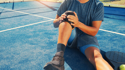Brace, knee pain and man on tennis court with injury, medical crisis and accident outdoors....