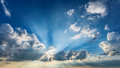 Fototapeta premium blue sky with sunrays shining through clouds blue sky sunrays background clouds sunlight shining nature peaceful